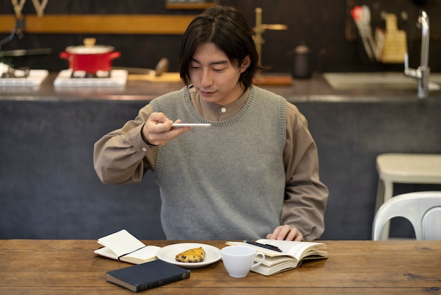 Hombre japonés que toma la foto de la empanada en un restaurante