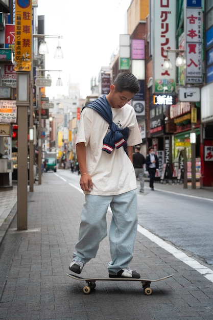 Foto hombre japonés de tiro completo con patineta