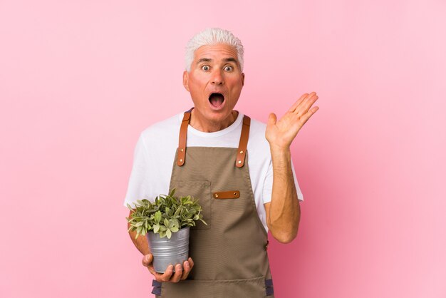 Foto hombre de jardinero de mediana edad aislado sorprendido y conmocionado.