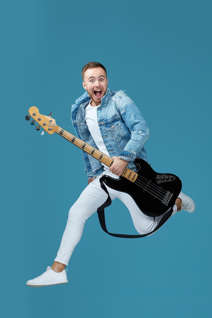 Hombre en jeans de camiseta de mezclilla con salto de guitarra