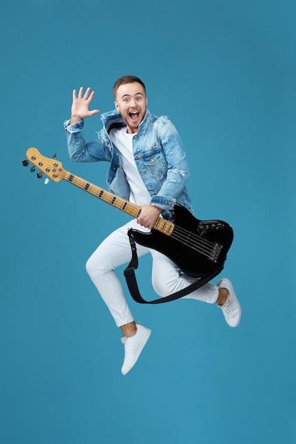 Hombre en jeans de camiseta de mezclilla con salto de guitarra