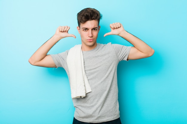 Foto hombre joven adolescente fitness se siente orgulloso y seguro de sí mismo, ejemplo a seguir.