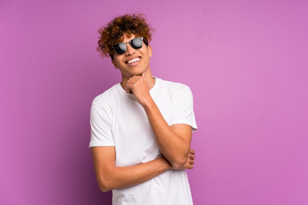 Hombre joven afroamericano con gafas y sonriendo