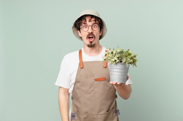 Hombre joven agricultor mirando muy conmocionado o sorprendido