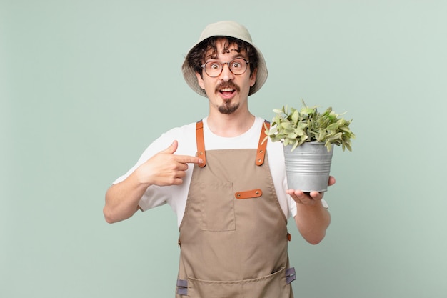 Hombre joven agricultor sintiéndose feliz y apuntando a sí mismo con un emocionado