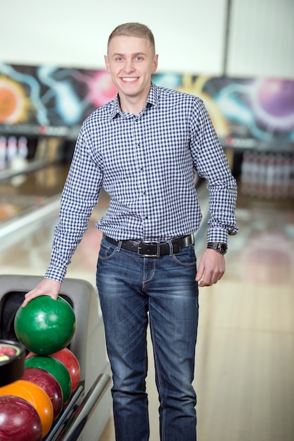 Foto hombre joven alegre que juega a bolos.