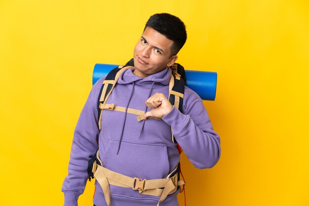 Hombre joven alpinista con una gran mochila aislada