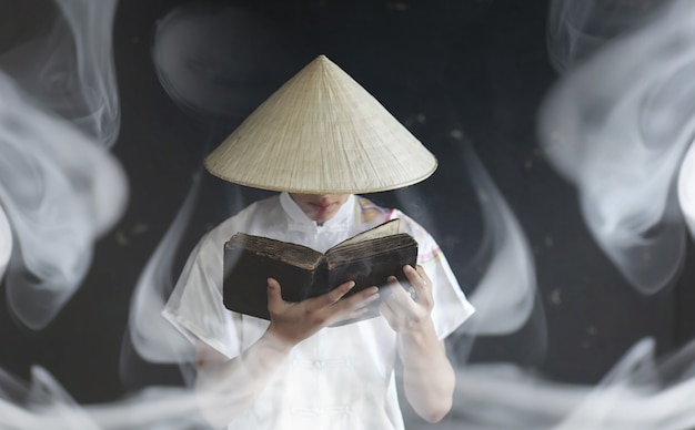 Hombre joven de apariencia asiática en un kimono ora con un libro