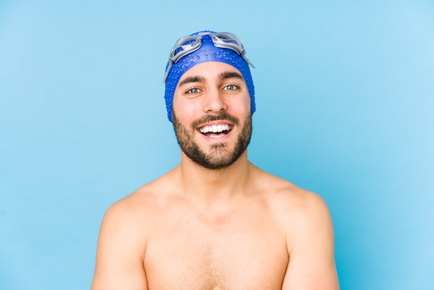 Hombre joven apuesto nadador aislado riendo y divirtiéndose.