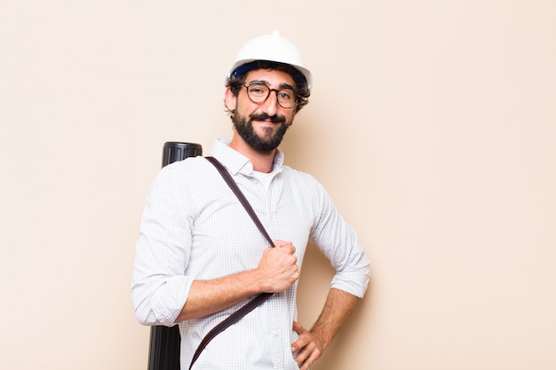 Hombre joven arquitecto barbudo orgulloso pose con un espacio de copia