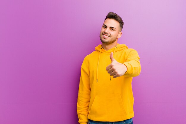 Hombre joven con aspecto casual sobre pared púrpura