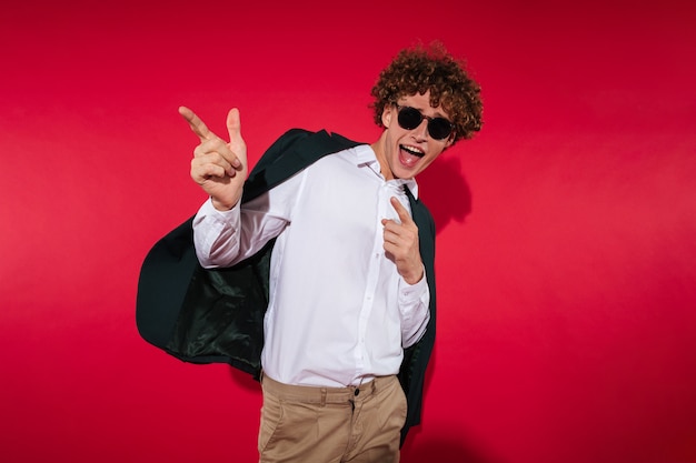 Foto hombre joven atractivo en camisa blanca y chaqueta señalando