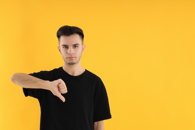 Hombre joven atractivo en camiseta sobre fondo amarillo