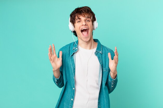 Hombre joven con auriculares sintiéndose feliz y asombrado por algo increíble