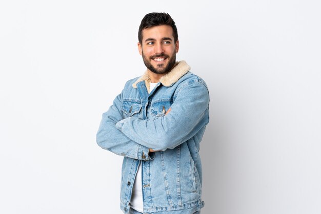 Hombre joven con barba con los brazos cruzados y feliz