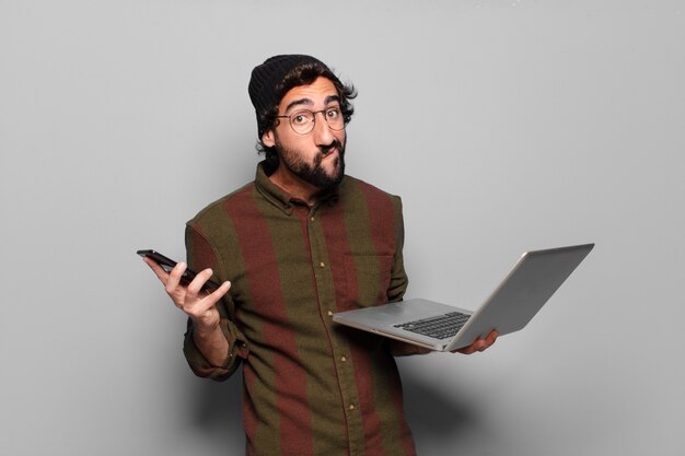 Hombre joven con barba con un ordenador portátil. concepto de redes sociales