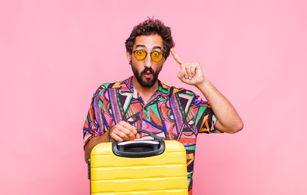 Hombre joven con barba que parece sorprendido, con la boca abierta, conmocionado, dándose cuenta de un nuevo pensamiento, idea o concepto