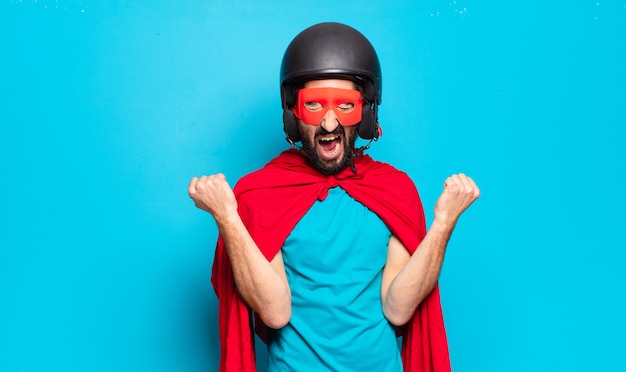 Hombre joven con barba. superhéroe loco y humorístico con casco y máscara