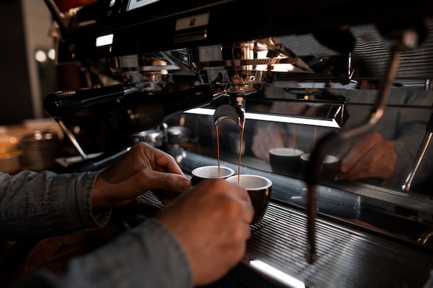 Hombre joven barista profesional prepara delicioso café caliente