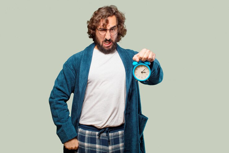 Foto hombre joven con bata de baño traje de noche con un reloj despertador