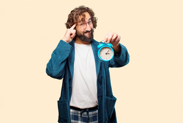 Foto hombre joven con bata de baño traje de noche con un reloj despertador