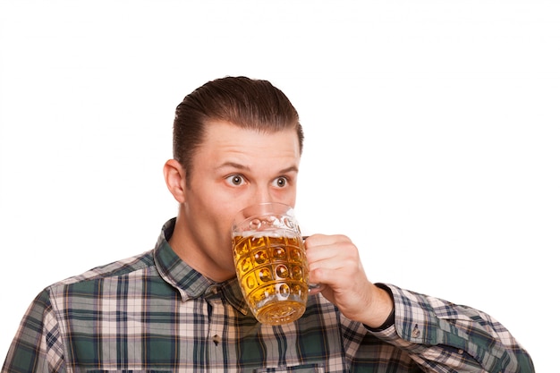 Hombre joven bebiendo cerveza aislado en blanco.