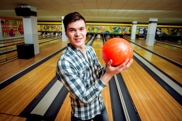 Hombre joven en la bolera con la bola.