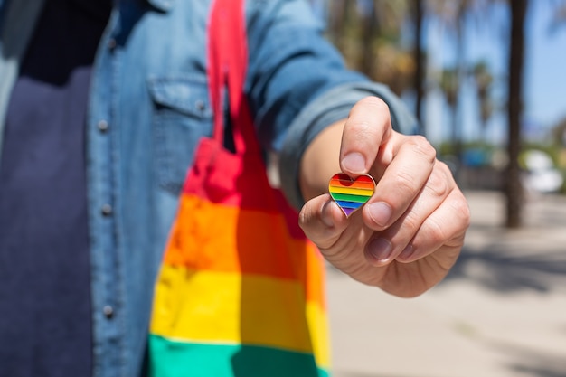 Hombre joven con bolsa reutilizable arco iris y símbolo de ciervo