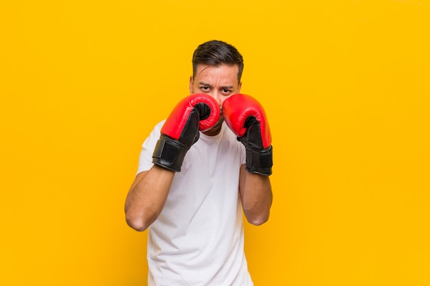 Hombre joven del boxeador del sur de Asia con guantes rojos.