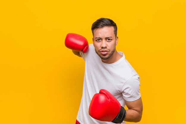 Hombre joven del boxeador del sur de Asia con guantes rojos.