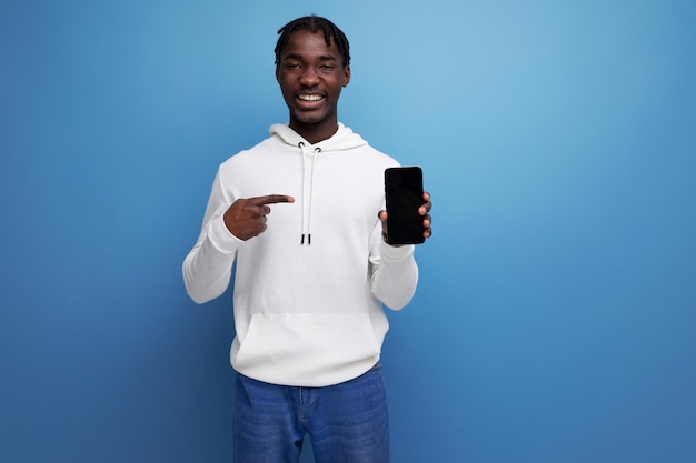 Hombre joven brunet americano sosteniendo teléfono móvil con maqueta de pantalla