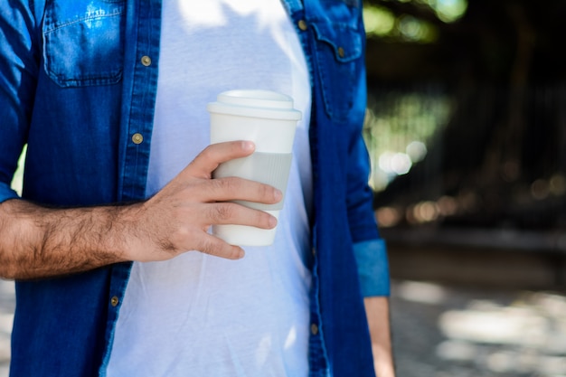 Hombre joven con café desechable.