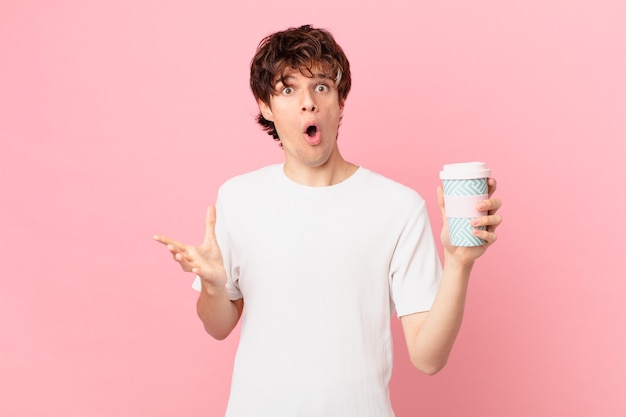 Hombre joven con un café sintiéndose extremadamente conmocionado y sorprendido