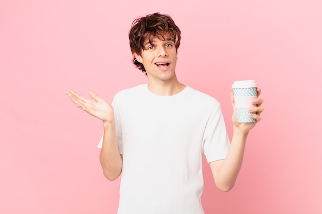 Hombre joven con un café sintiéndose feliz, sorprendido al darse cuenta de una solución o idea