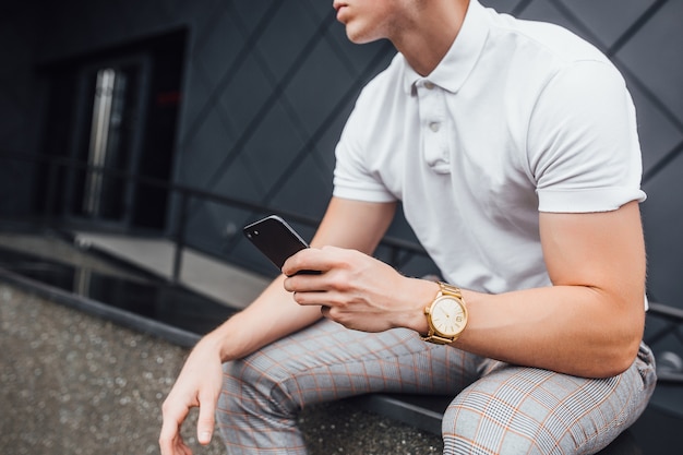 Hombre joven con una camisa blanca con pantalón gris