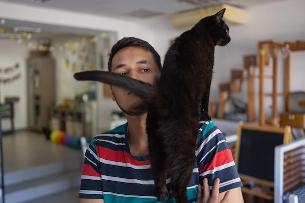 Hombre joven en camiseta sosteniendo un gato