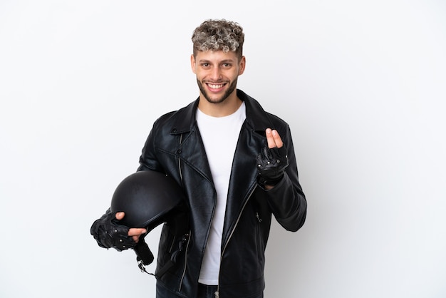 Hombre joven con un casco de motocicleta aislado sobre fondo blanco haciendo gesto de dinero