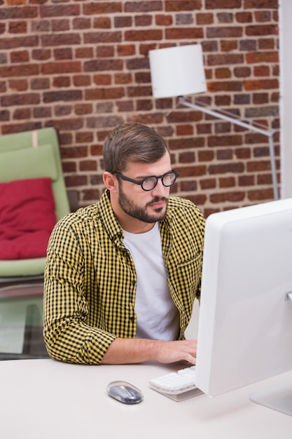 Hombre joven casual serio que usa la computadora