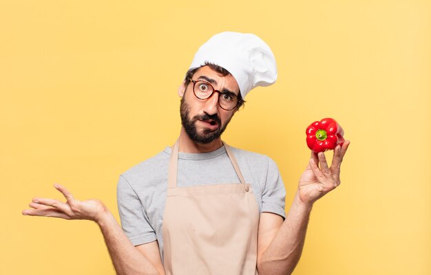 Hombre joven chef barbudo dudando o expresión incierta