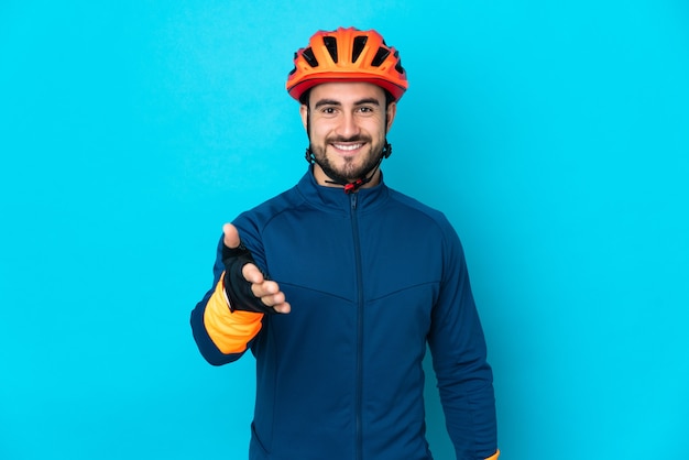 Hombre joven ciclista aislado estrechándole la mano para cerrar un buen trato