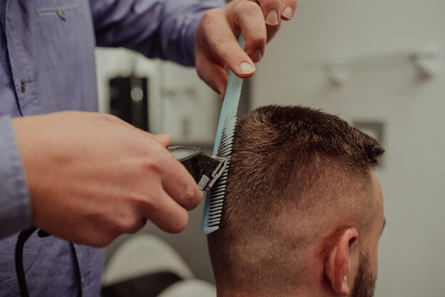 Hombre joven en el concepto de servicio de cuidado del cabello de barberíaHombre joven en el concepto de servicio de cuidado del cabello de barbería