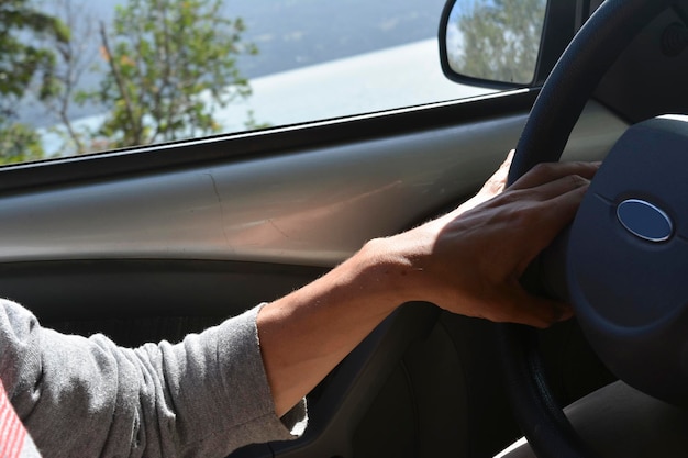 un hombre joven conduciendo un coche tomando el volante con las llaves en