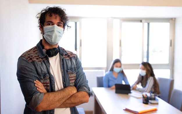 Foto hombre joven creativo con fondo de reunión de mascarilla