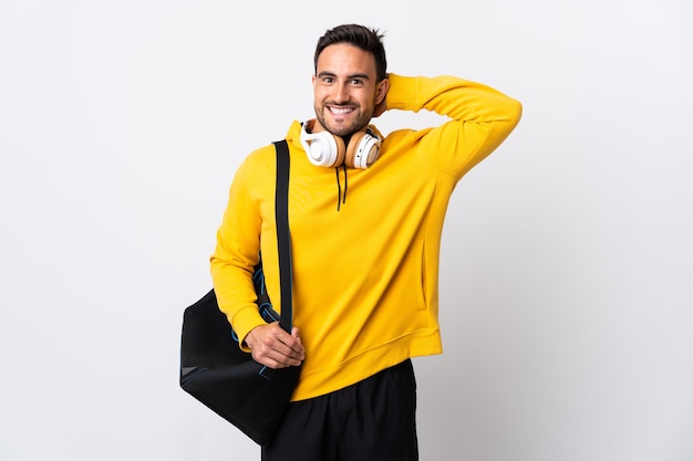 Hombre joven deporte con bolsa de deporte aislado sobre fondo blanco riendo