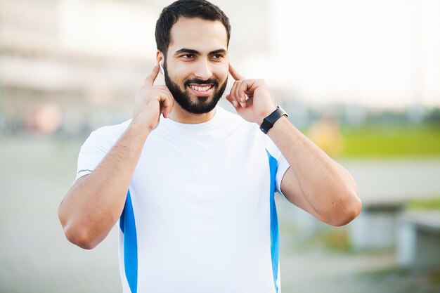 Hombre joven y deportivo entrenando al aire libre en ropa deportiva