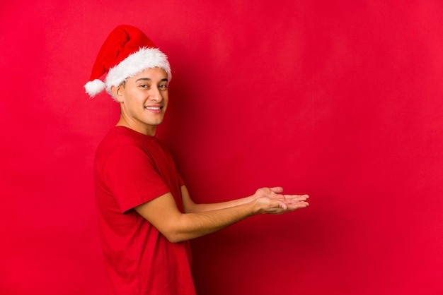 Hombre joven el día de Navidad con un espacio de copia en una palma.