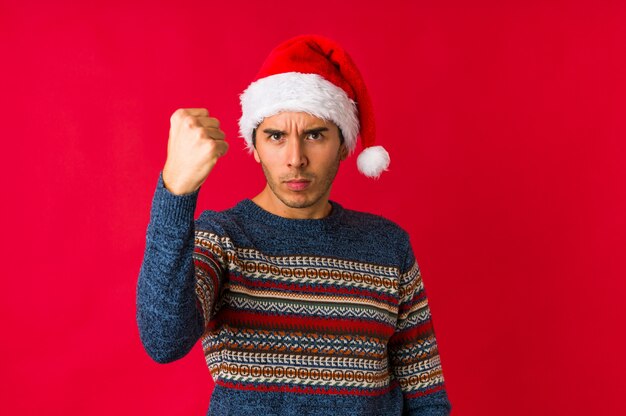 Hombre joven el día de Navidad que está aburrido, cansado y necesita un día de relajación.