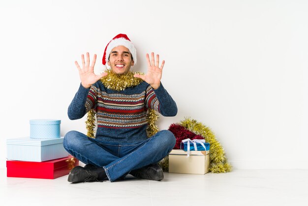 Hombre joven el día de Navidad que se siente confiado, cruzando los brazos con determinación.