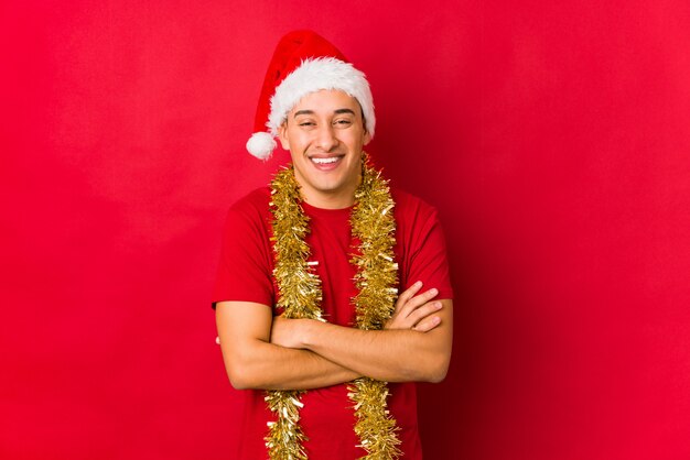 Hombre joven el día de Navidad riendo y divirtiéndose.