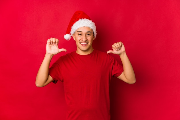 El hombre joven el día de Navidad se siente orgulloso y seguro de sí mismo, ejemplo a seguir.